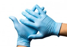 close up of Doctors hands putting on nitrile gloves isolated over white.