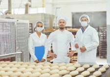 Technologist and baker inspect the bread production line at the bakery.